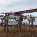 A happy group of three unguided caribou hunters getting ready to be flown out of the field in a float plane.
