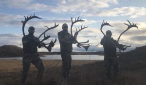 Hunters holding caribou antlers